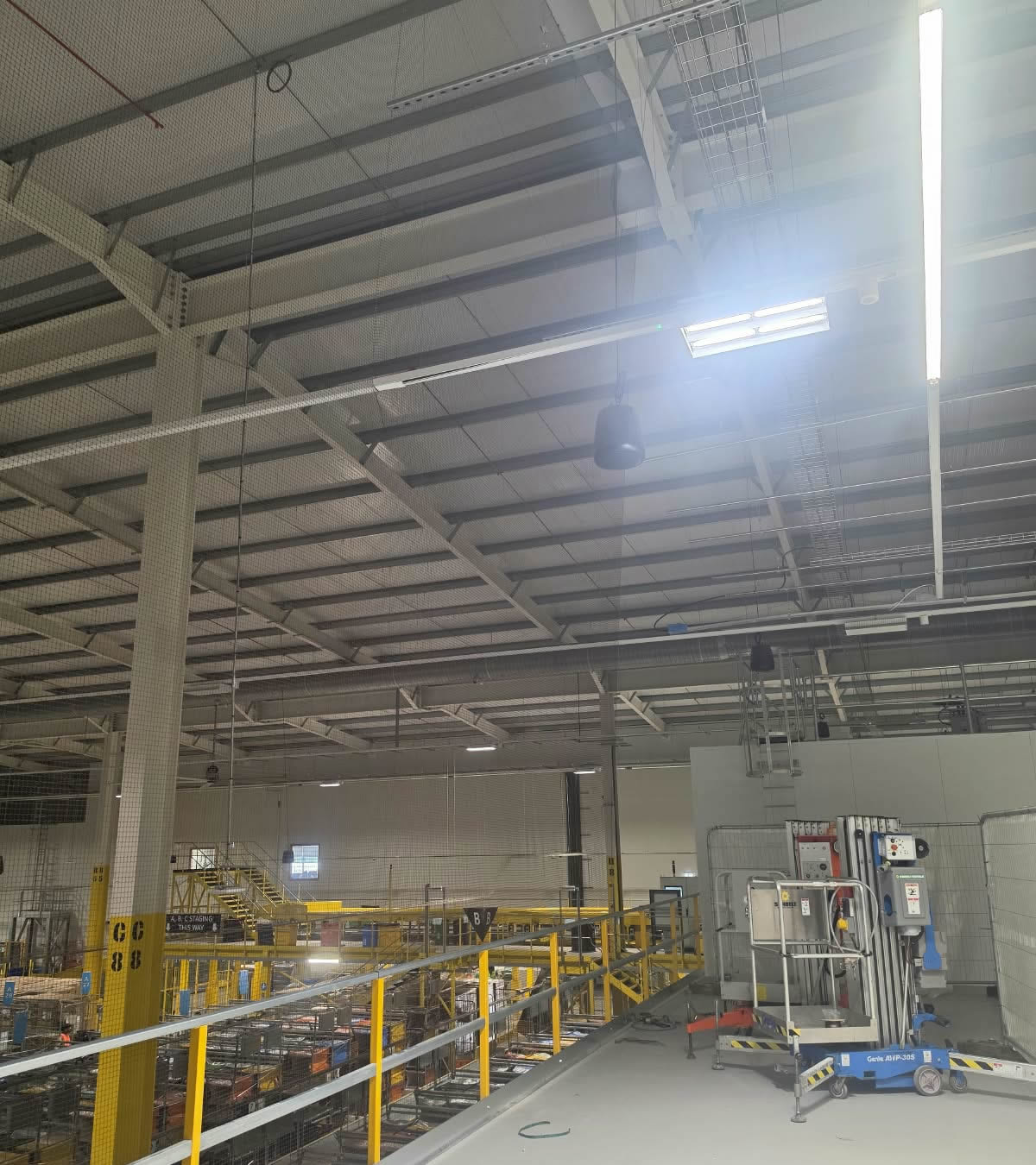 Bird netting beside the industrial mezzanine beneath overhead services
